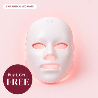 A white LED face mask glowing with pink light, centered on a soft pink background with promotional text overlays reading 'AWARDED #1 LED MASK' and 'Buy 1, Get 1 FREE'.